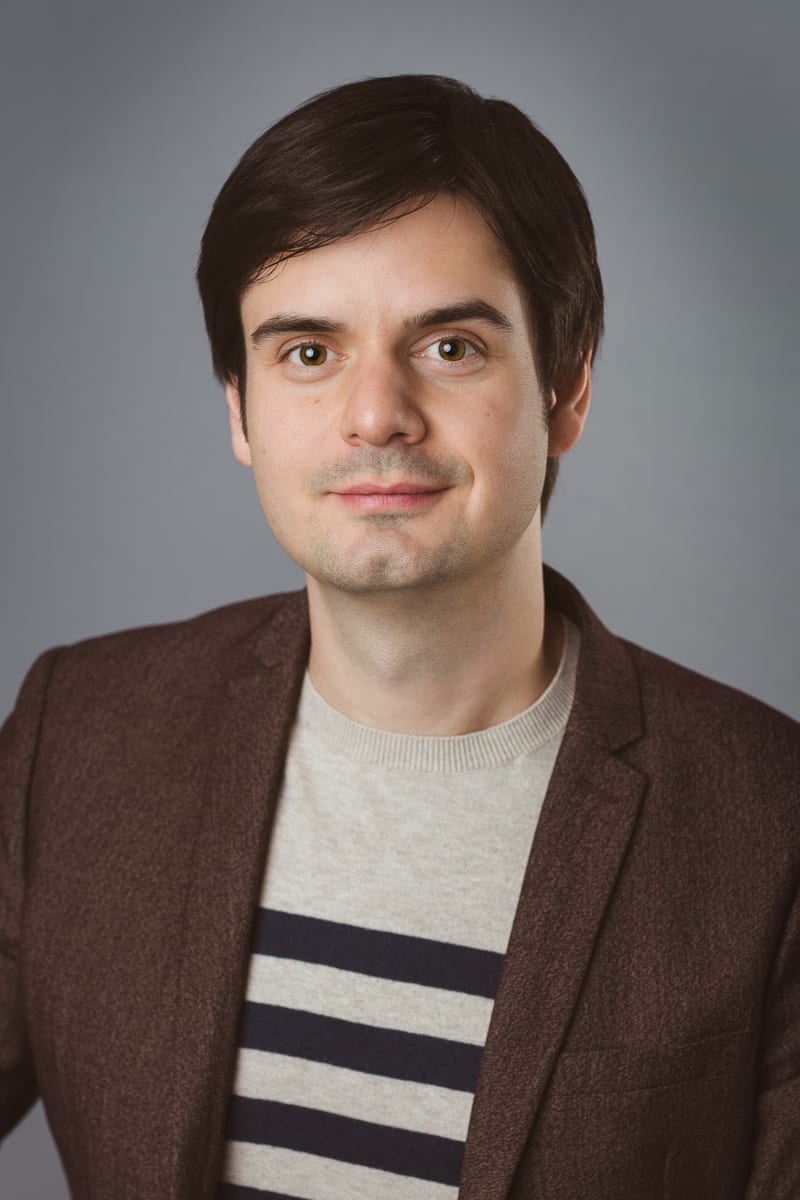 Professional business headshot featuring polished styling and confident posture