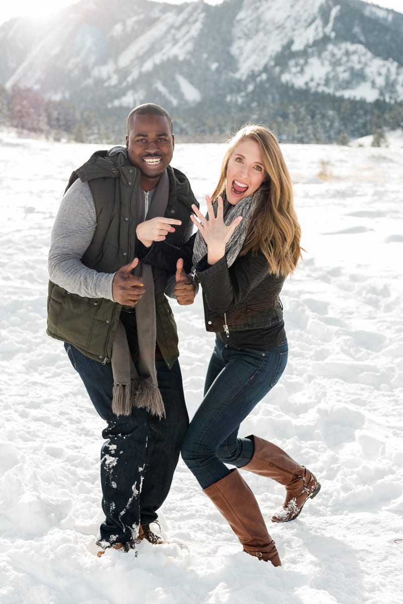 Portrait of bride-to-be in winter engagement session wearing casual clothing with snowy mountain backdrop