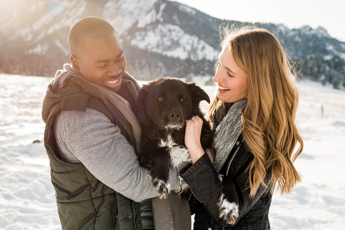 Newlyweds-to-be embracing on snowy mountain overlook at Chautauqua Park engagement photoshoot