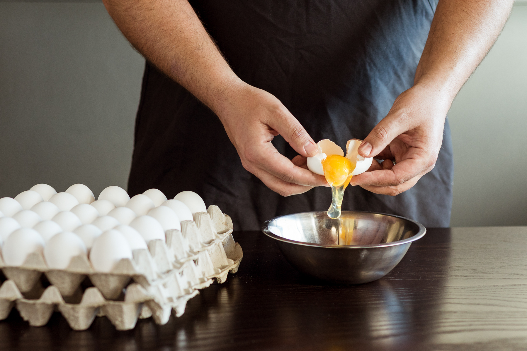 Chef cracks eggs at Mici Handcrafted Italian in Denver, CO. 