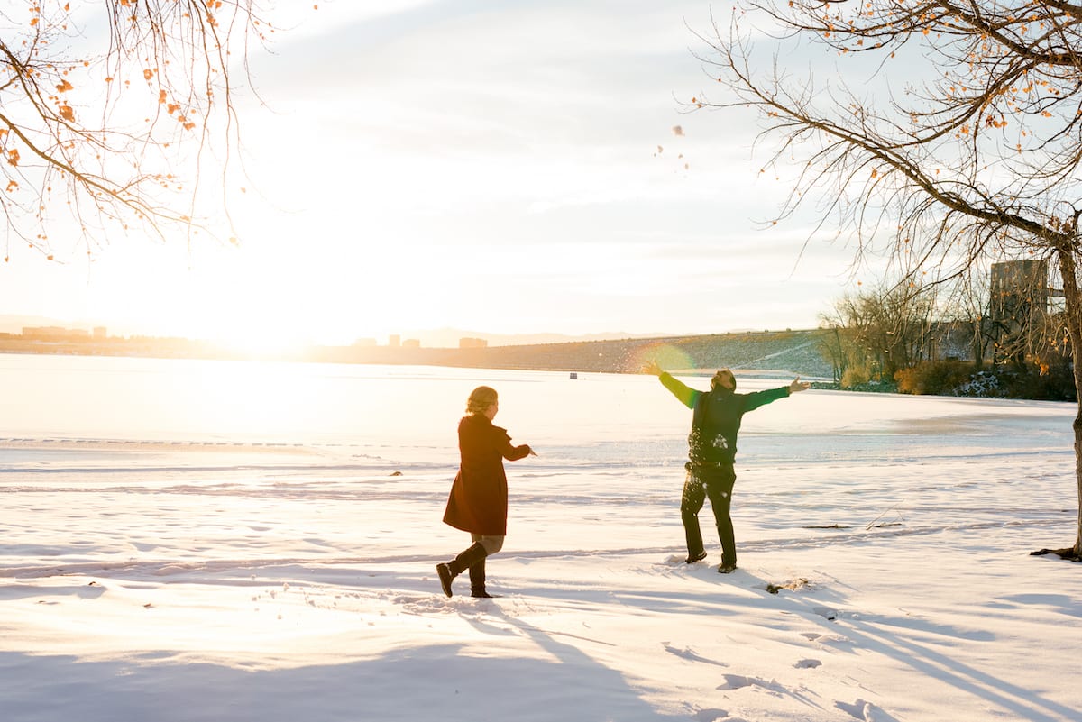 cherry creek state park engagement photos, a couple throwing snow.