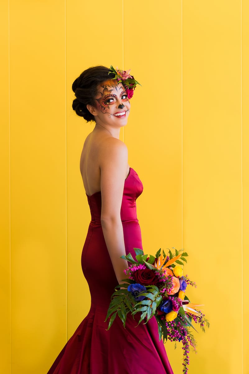 bride poses with colorful bouquet and candy skull makeup