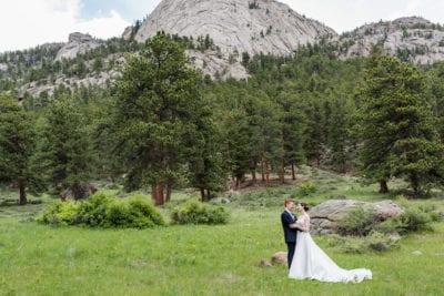 bride and groom in front of a mountain