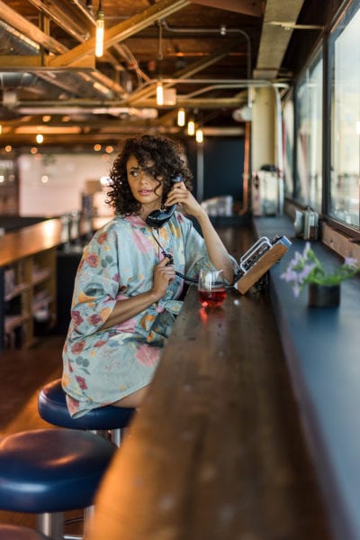 Model in teal robe on the phone