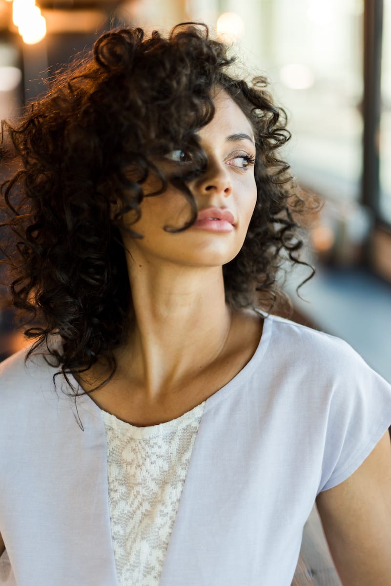Model in white top has hair sweeping past one eye | boudoir | Boudoir Photography | model | From the Hip Photo