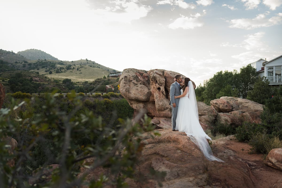 Bride and groom share a kiss during ceremony with mountain landscape framing the moment at Willow Ridge Manor