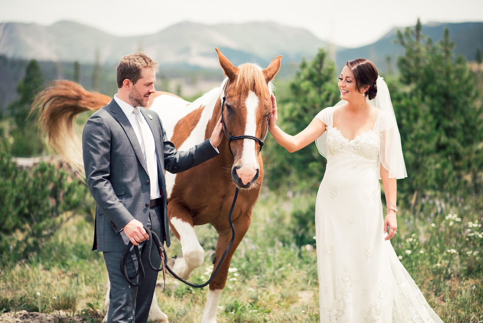 Bridal party gathered on a wooden bridge at Devil's Thumb Ranch during golden hour