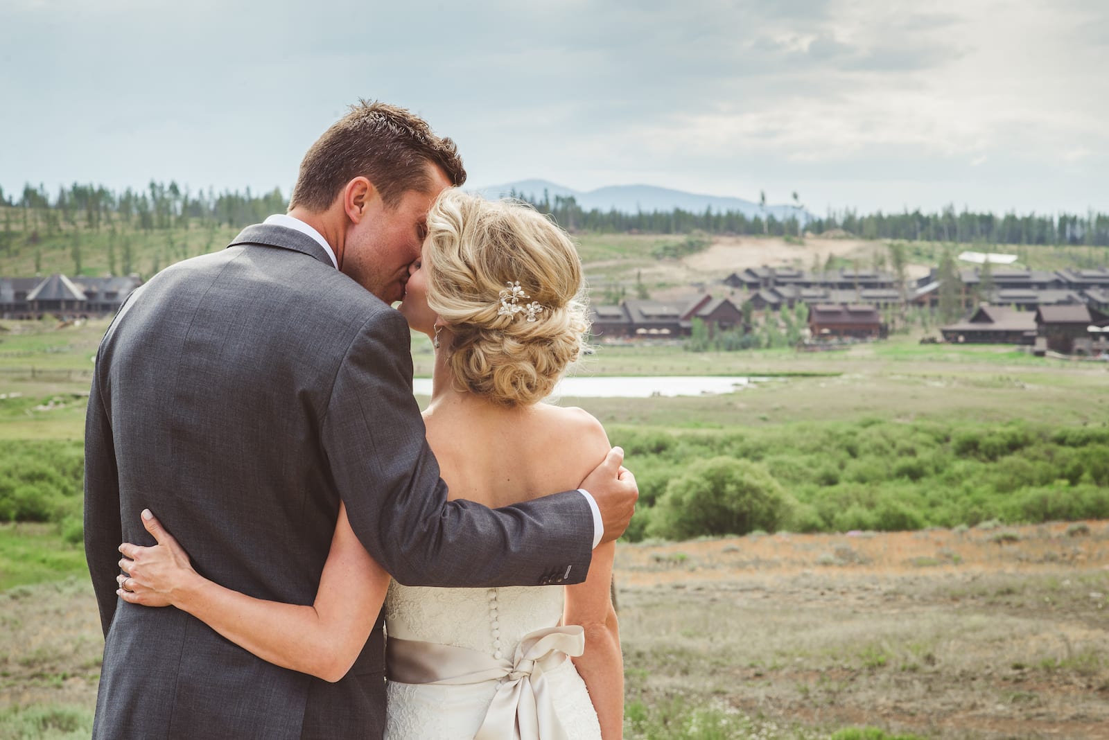 Bride and groom sharing a quiet moment on the grounds of Devil's Thumb Ranch with mountain views in the background