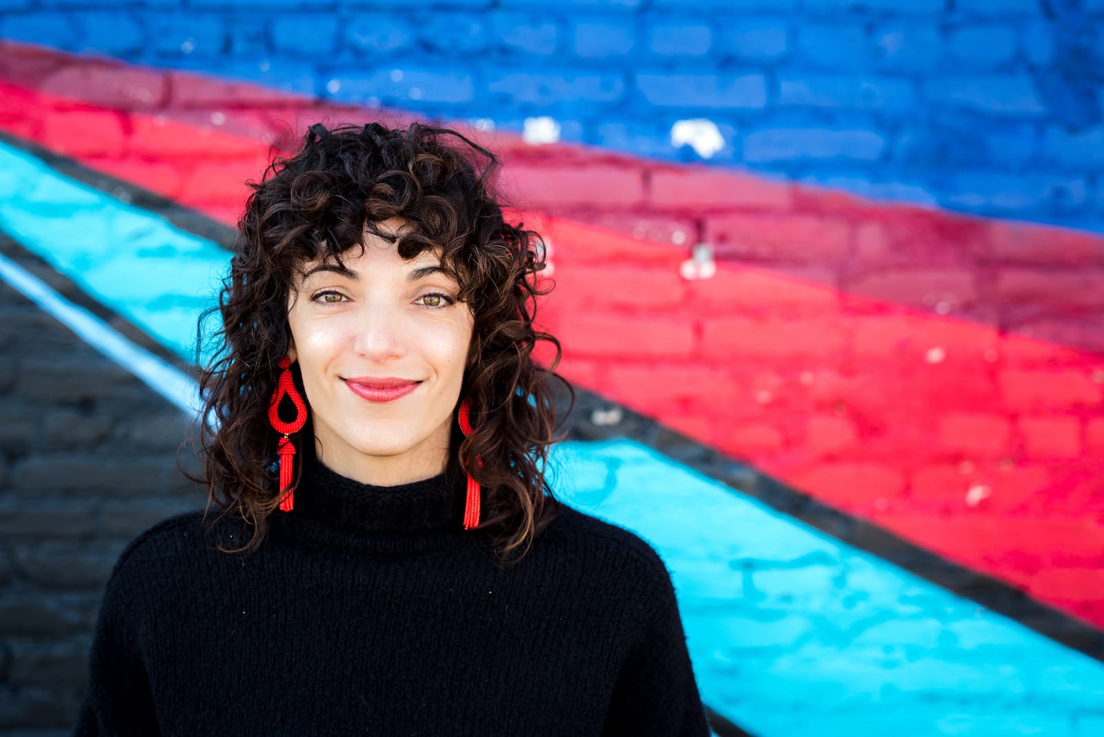 Professional headshot in modern urban setting with architectural details