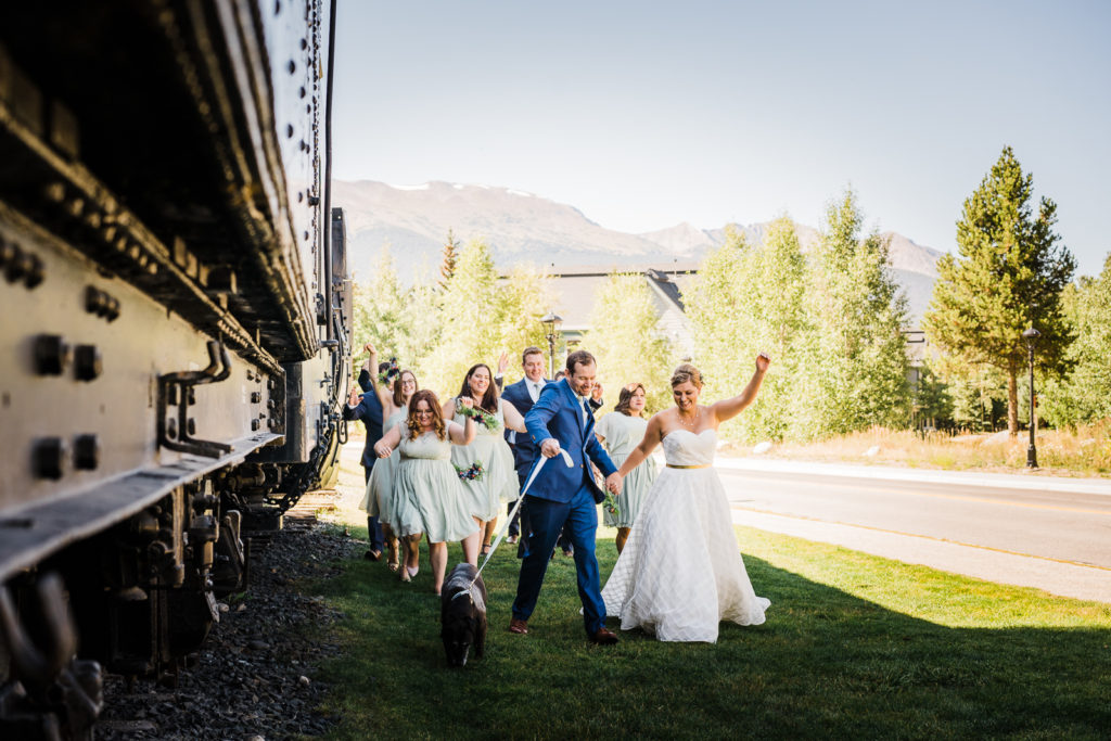 Mountain wedding in Frisco | Bride, groom, dog, bridesmaids and groomsmen dance along the side of train car
