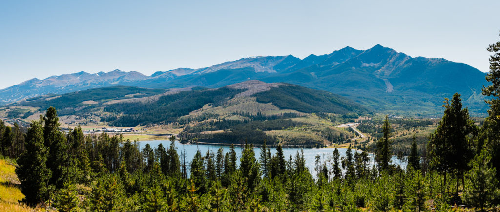 Wide view of valley and lake beneath mountain