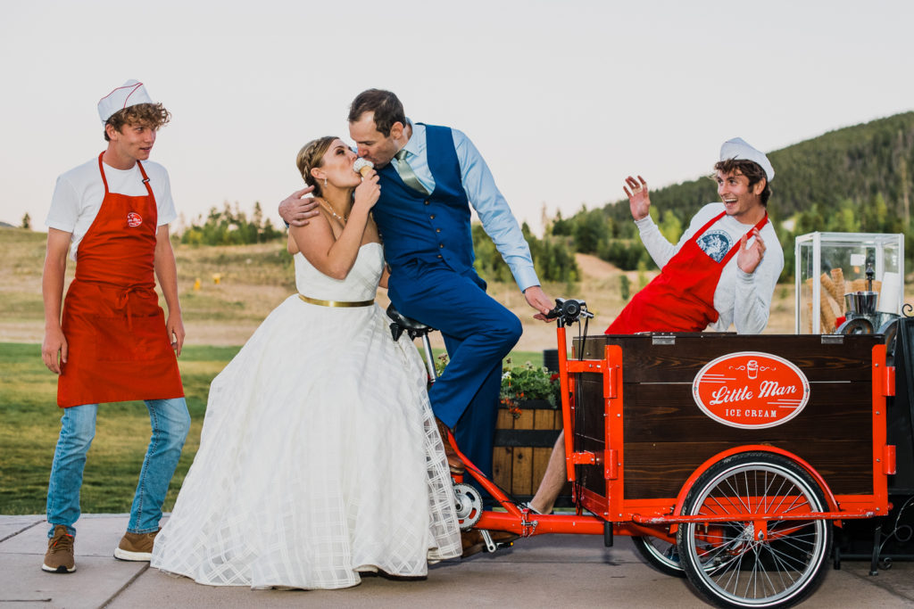 Mountain wedding in Frisco | Little man ice cream employees watch as groom and bride share ice cream cone