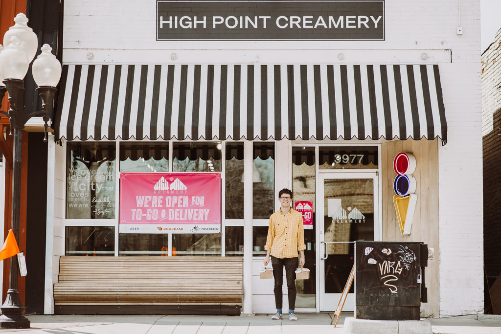 Product Photography | Man stands in front of creamery carrying two baskets of ice-cream cups | High Point Creamery, Denver, Colorado