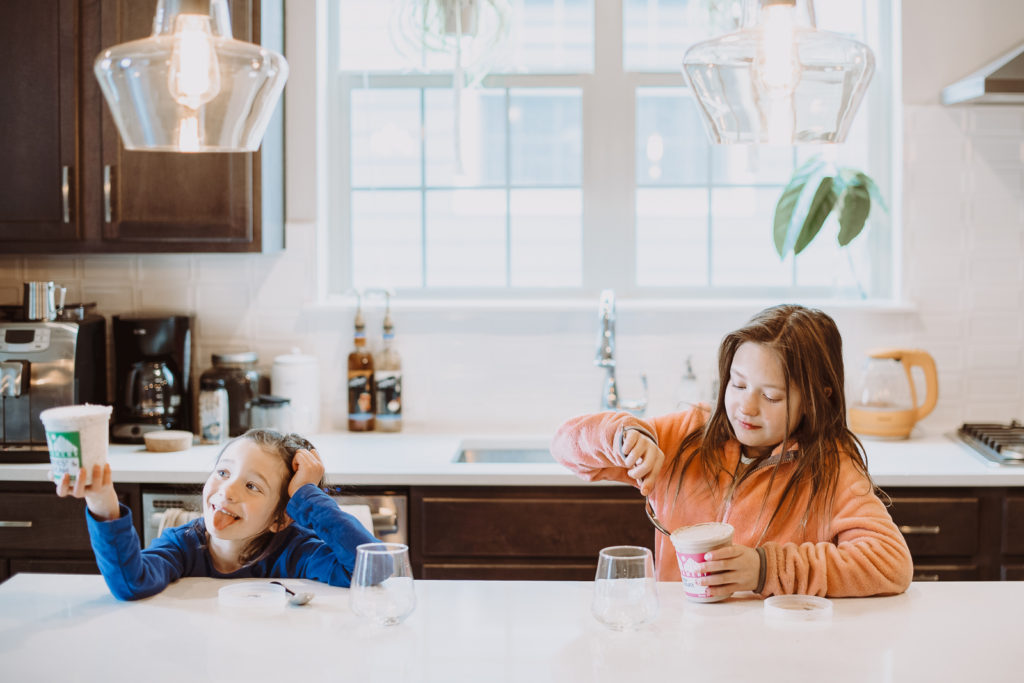 Product Photography | Two girls sit by marble kitchen island eating ice cream | High Point Creamery, Denver, Colorado