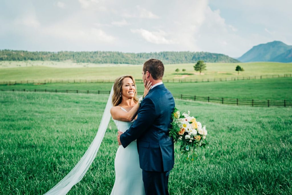 Wedding photos | Bride and groom embrace in mountain field | Spruce Mountain Ranch, Larkspur, Colorado