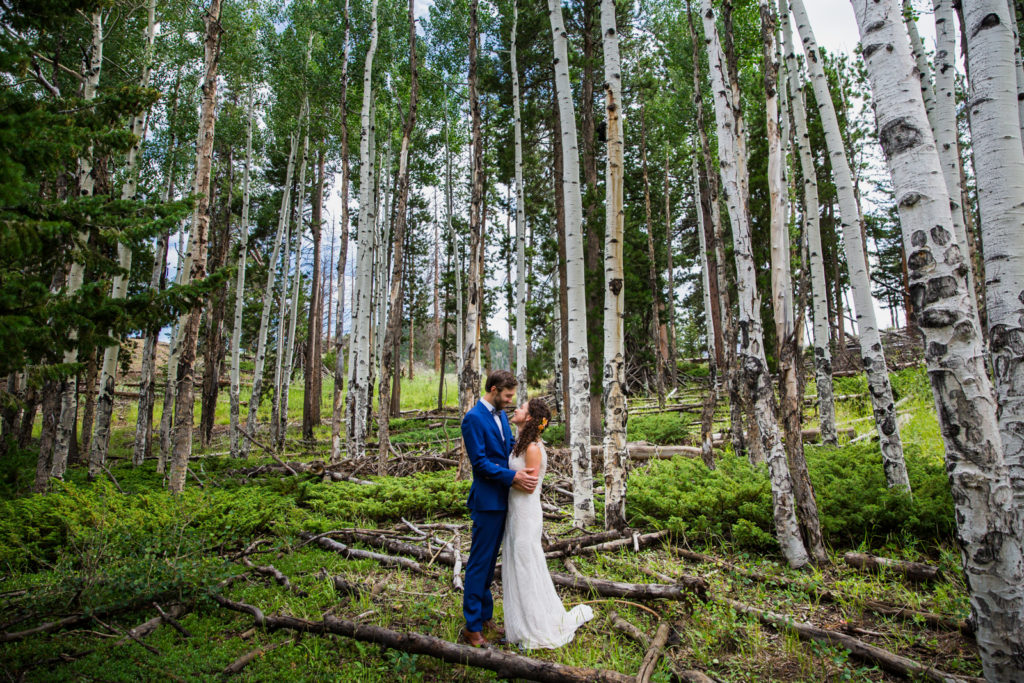 Wedding photography | Bride and groom embrace in forest of aspens