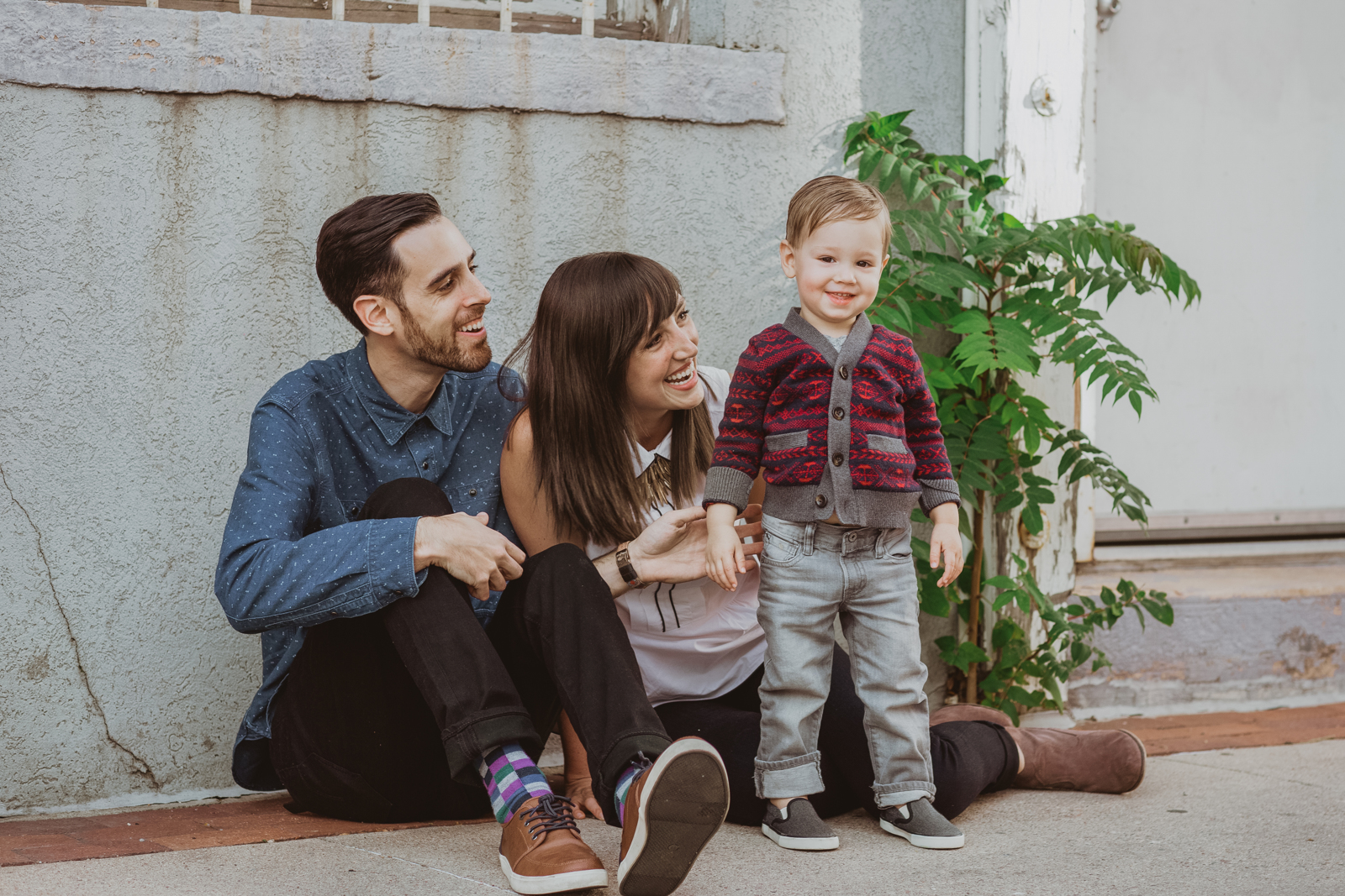 Family enjoying candid moment on Pearl Street Boulder during outdoor portrait session with mountain views