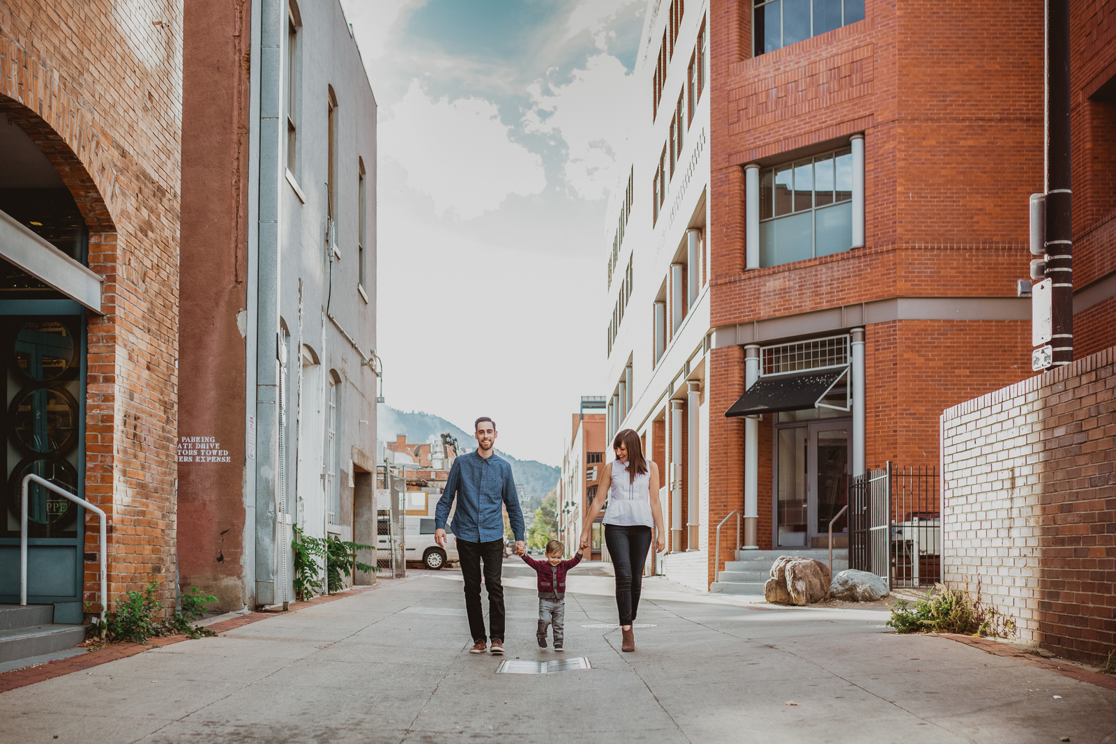 Family portrait session at Pearl Street Boulder featuring mountain backdrop and urban setting
