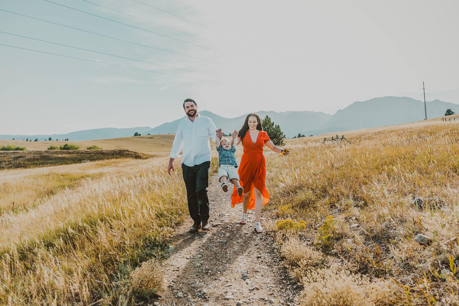 Family enjoying meadow landscape with iconic Flatirons mountain formations