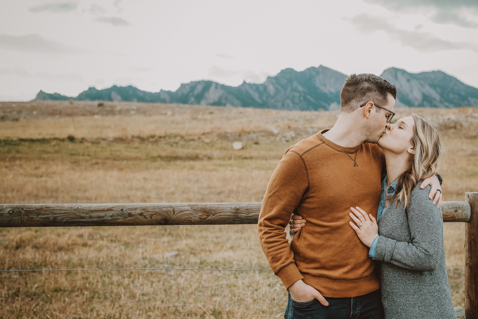 Bride and groom holding hands walking through wildflower meadow