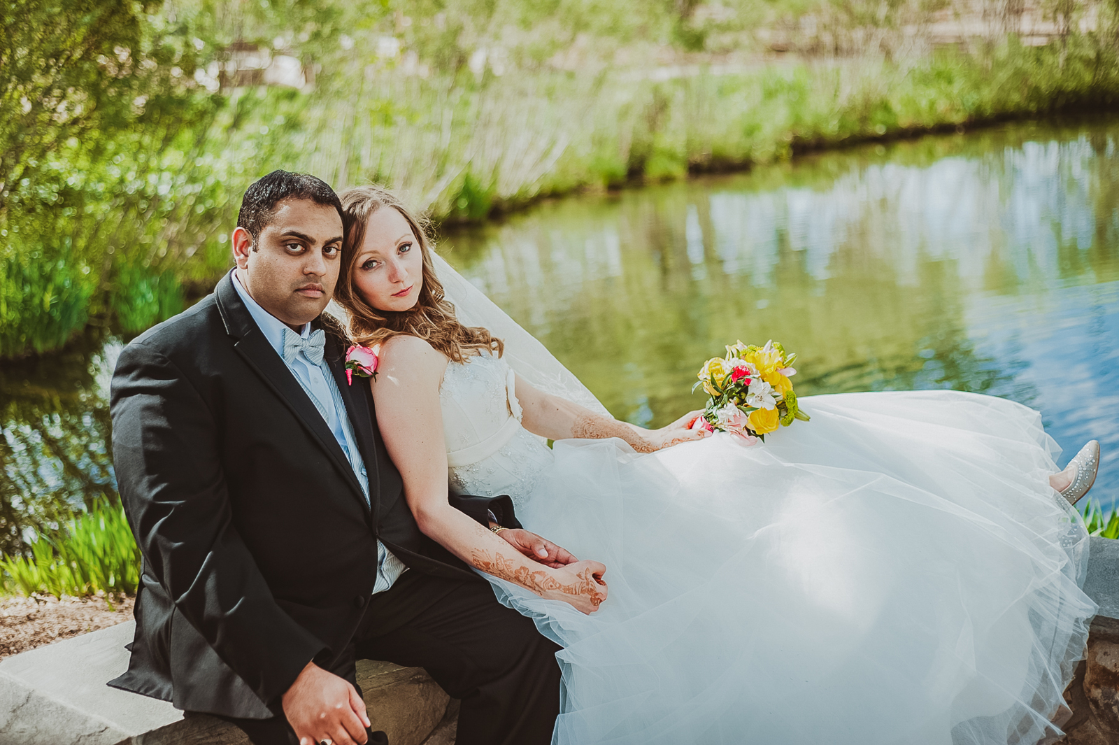 Newlyweds exchanging vows in garden setting with loved ones gathered around