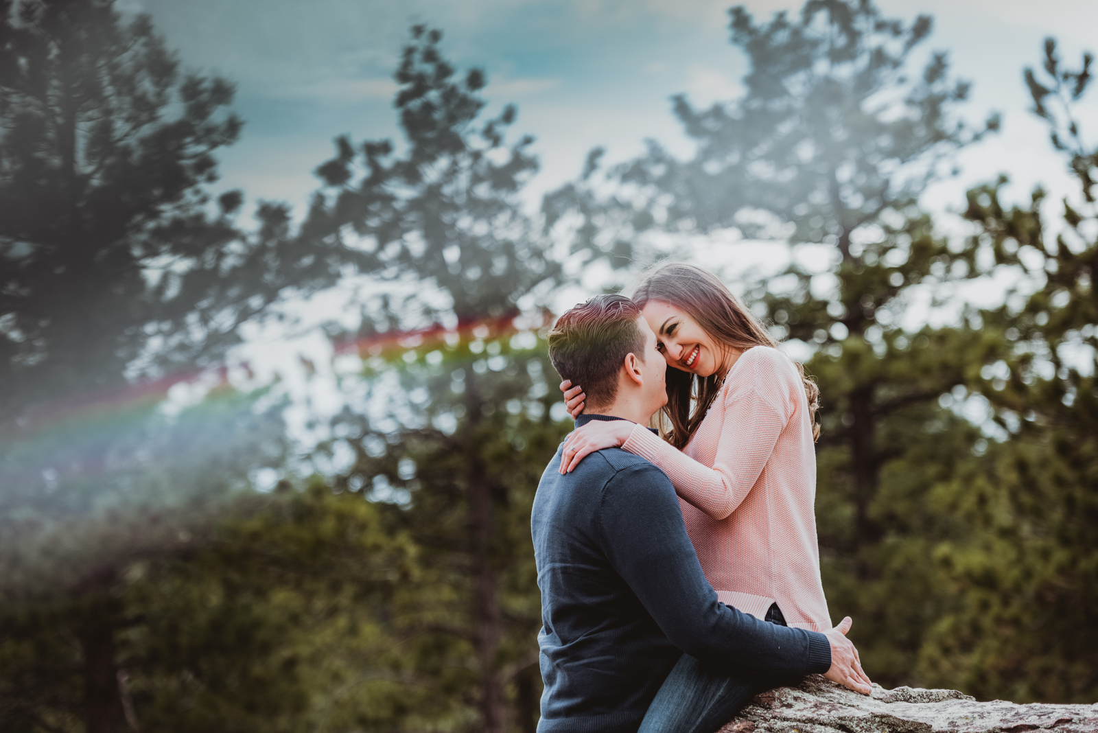 Couple embracing on rocky overlook at Lookout Mountain Golden Colorado with mountain valley view