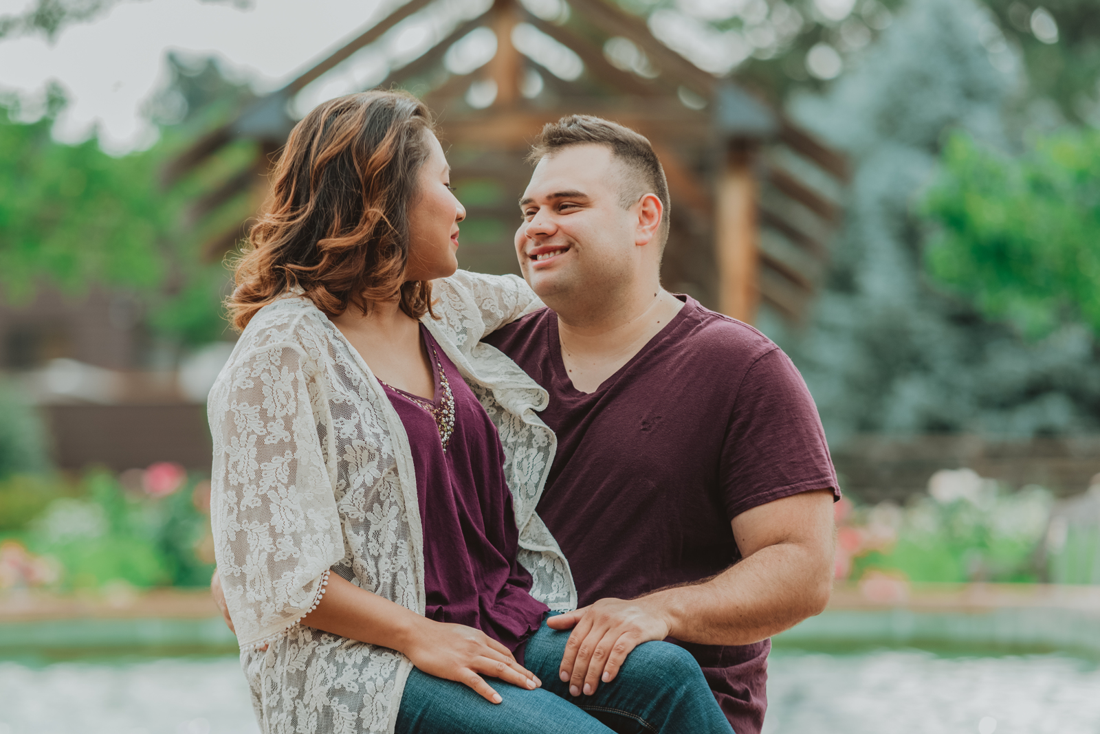 Extended family group laughing together in Hudson Gardens with colorful flower gardens behind them