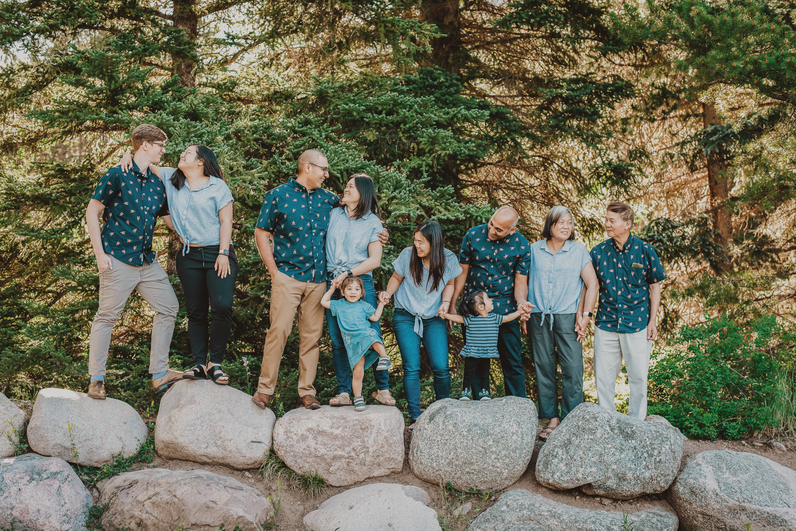 Large family gathering together laughing with mountain forest backdrop in Vail Colorado