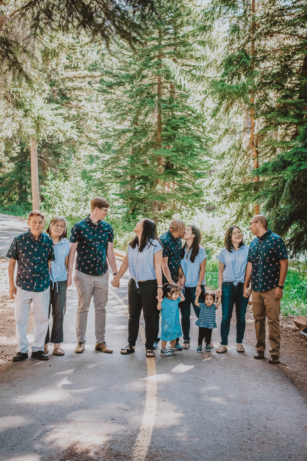 Tall vertical portrait of woman in light-colored dress standing near mountain scenic overlook