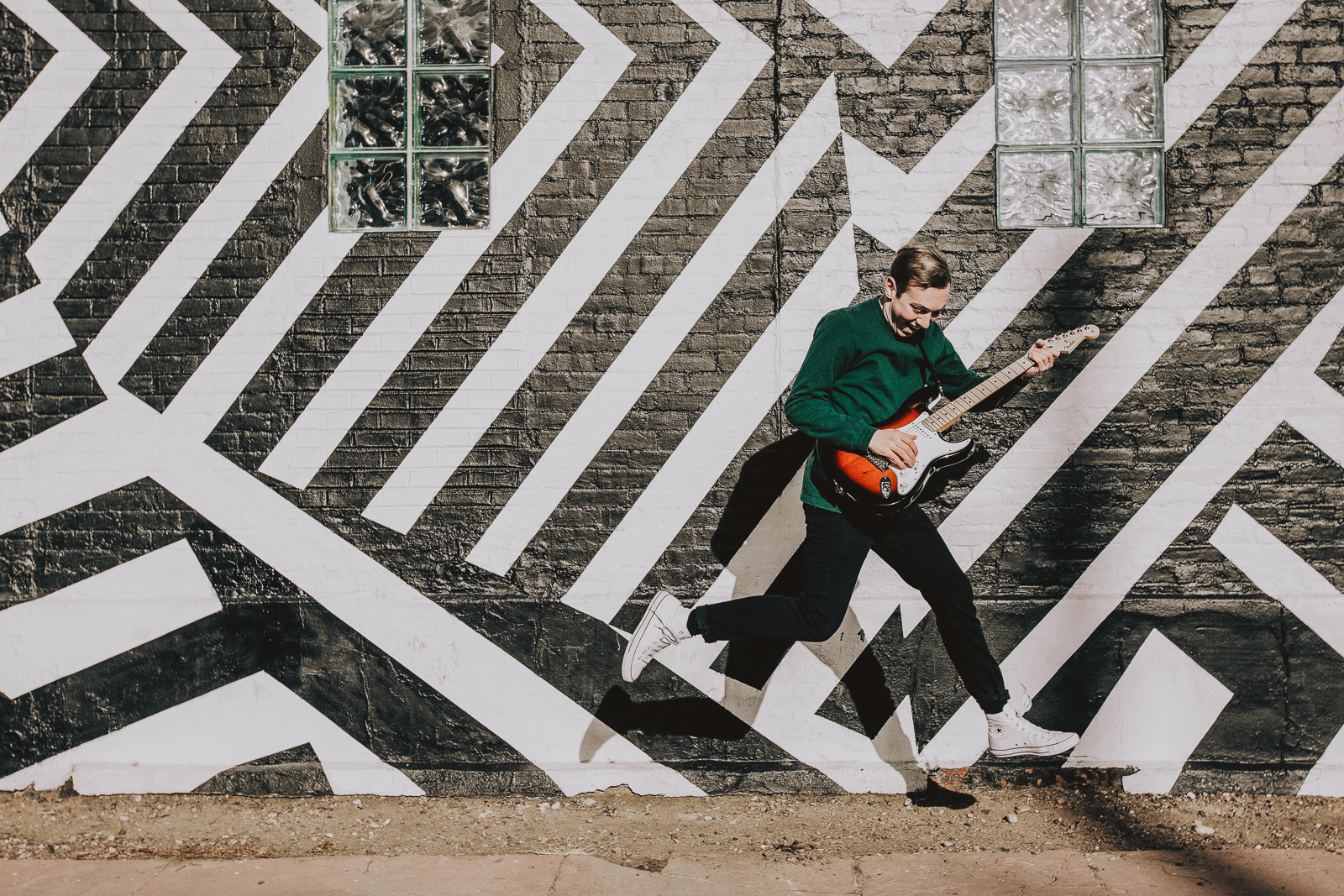 Couple laughing together during RiNo Denver engagement session near Larimer Street murals