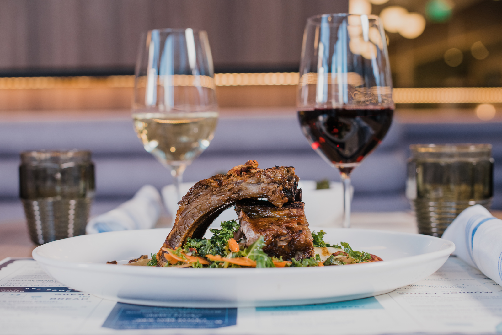 Colorado Hotel & Food Photography | The Original, The Rally Hotel | Close up on ribs with wine glasses in the background