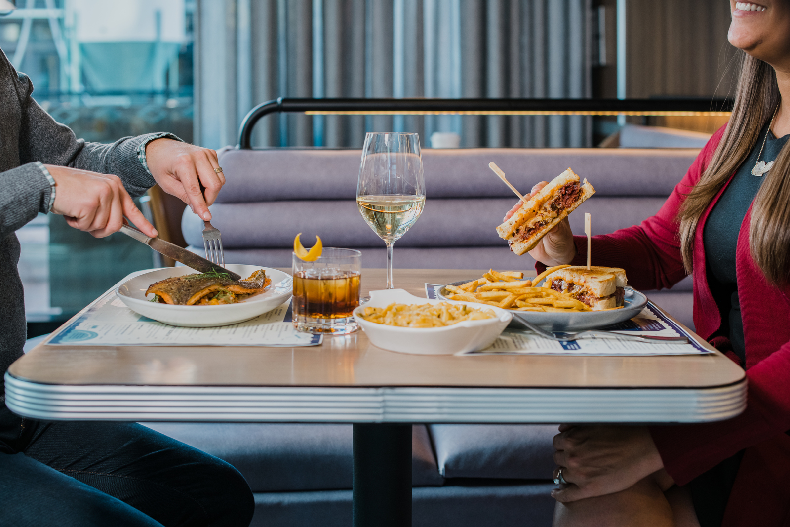 Colorado Hotel & Food Photography | The Original, The Rally Hotel | Woman and man enjoy meal with alcoholic beverages