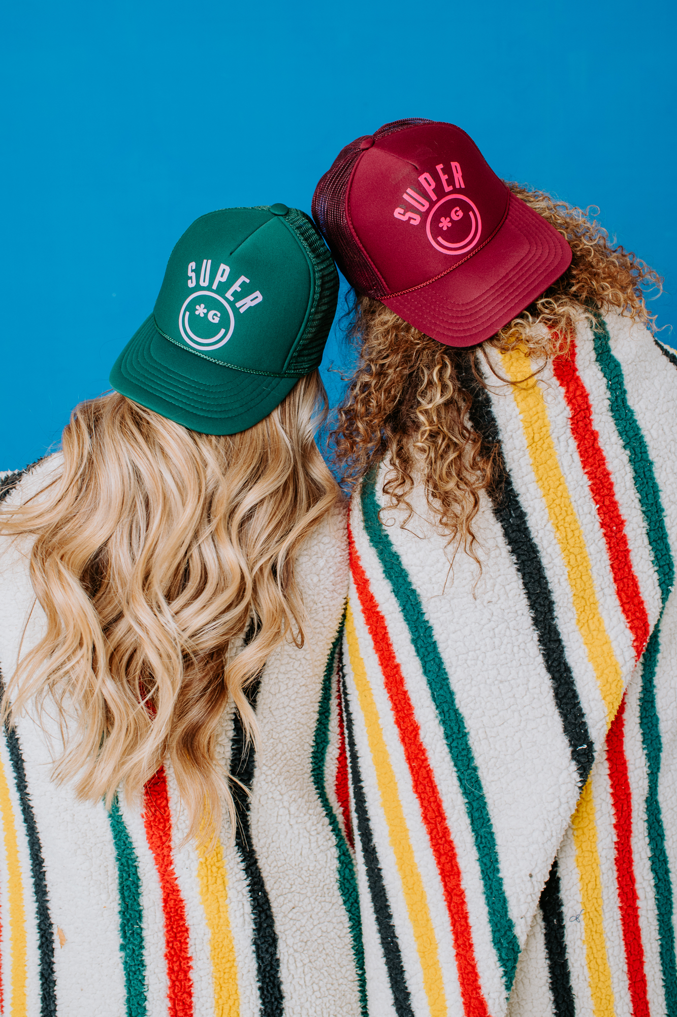 Super G Apparel Product shoot | Brand photography | Models turned away wearing baseball caps and multicolored blanket | Denver, Colorado