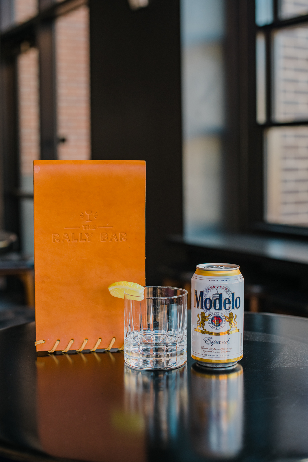 Colorado Hotel & Food Photography | The Original, The Rally Hotel | Table with menu, glass with lemon slice and a can of Modelo