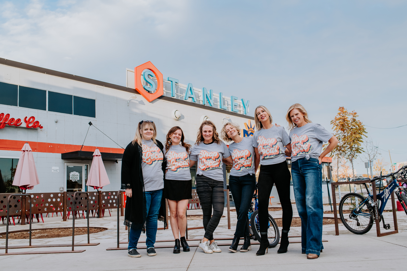 Business Photography | Six women pose outside buisiness wearing themed shirts | Denver, Colorado