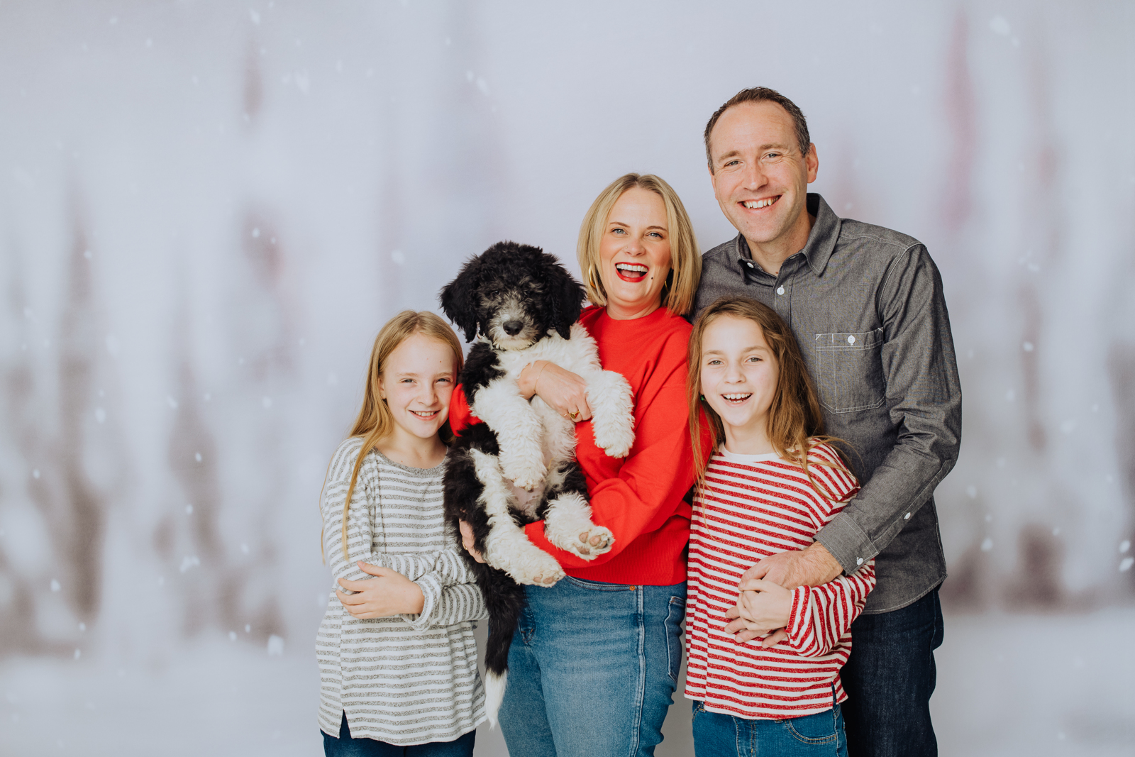 Joyful family laughing together during Denver holiday photo session with warm lighting