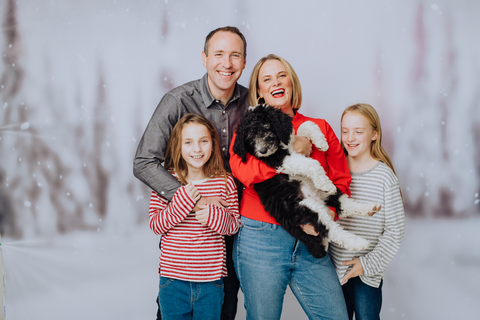 Family group posed in studio during professional holiday portrait session with festive backdrop