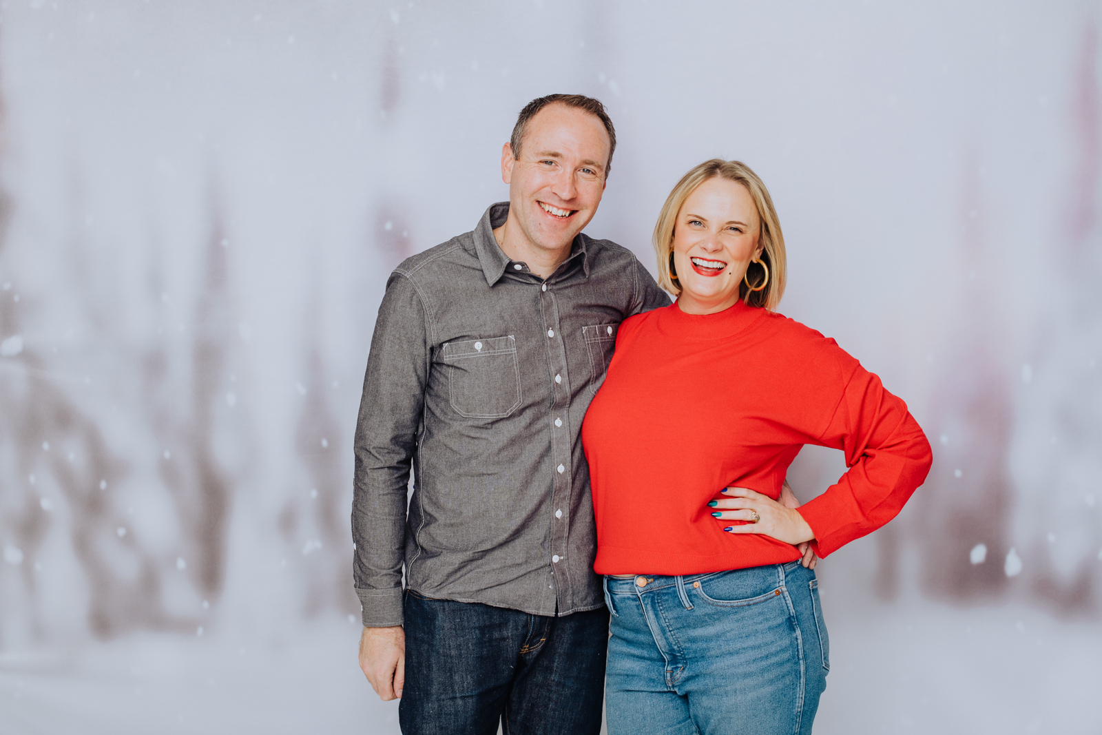 Newlywed couple posing together for holiday family portrait with warm winter backdrop