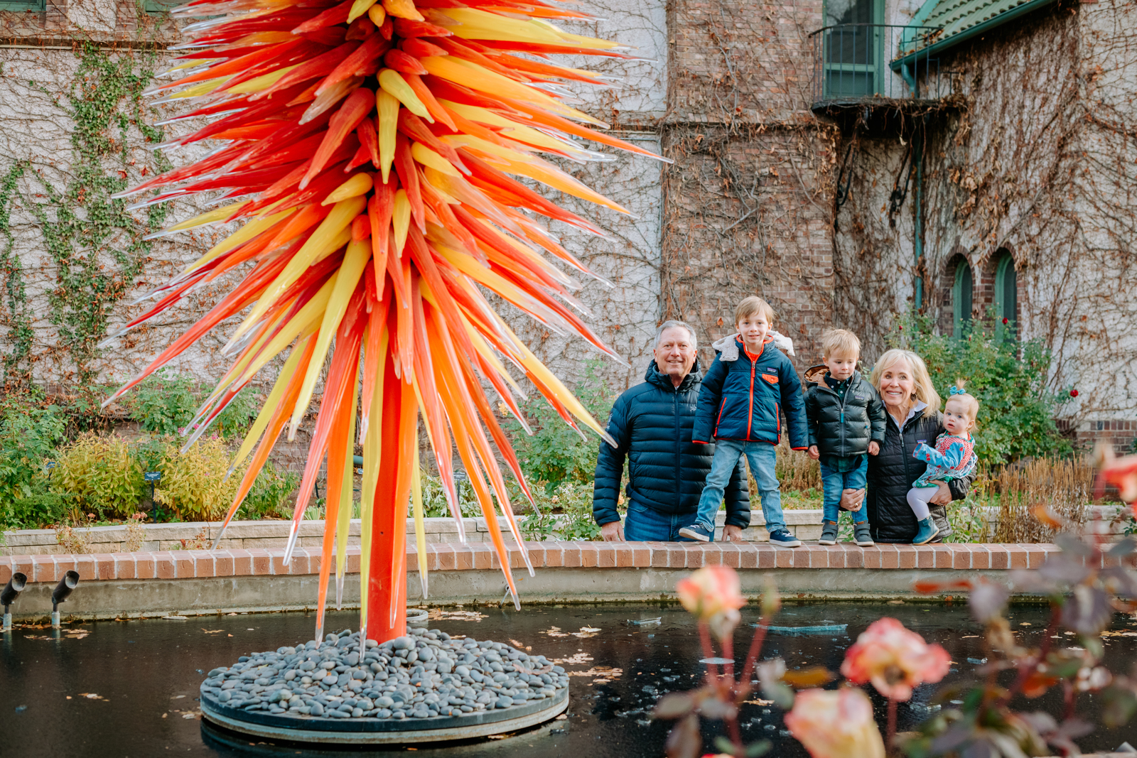 Grandparents and grandchildren sharing a joyful moment among the garden paths at Denver Botanic Gardens