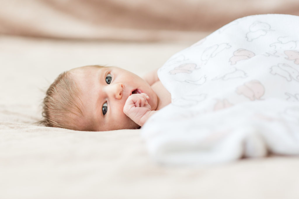 Newborn photography | Newborn baby is sucking his thumb in bed