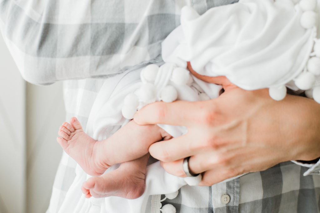 Newborn photography | Parent's hold a newborn baby showing her tiny feet