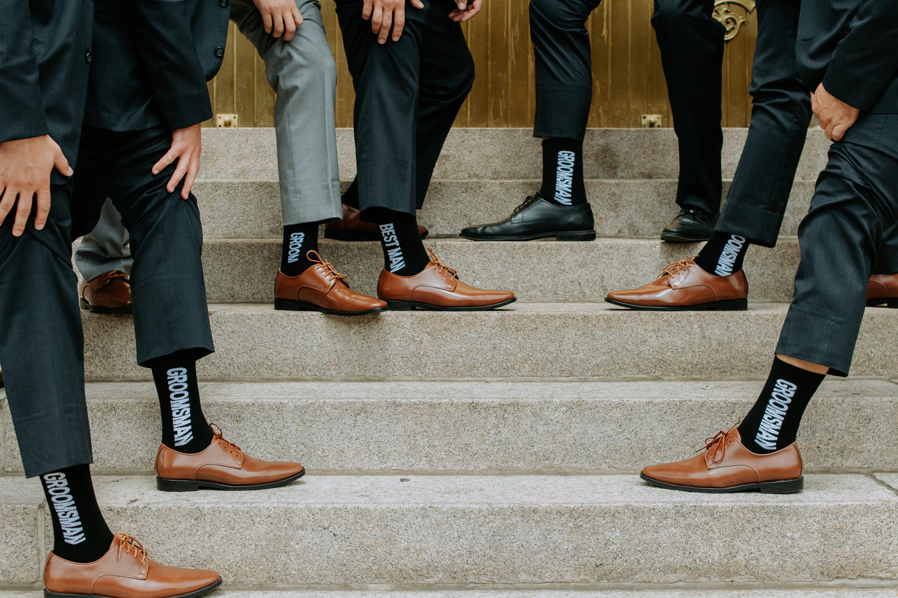 Wedding photography | Groom and groomsmen show off their socks on staircase | Cathedral Basilica of the Immaculate Conception, Denver