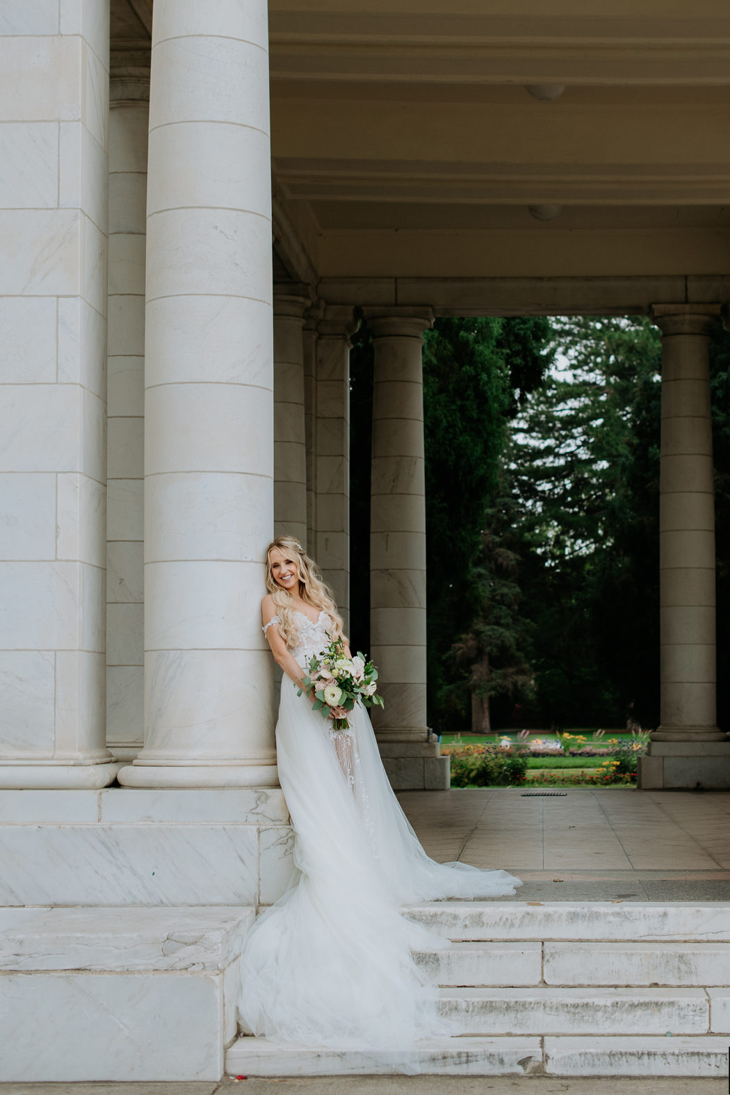 Wedding Photography | Bride stands on steps, leaning against pillar | Cheeseman Park, Denver 