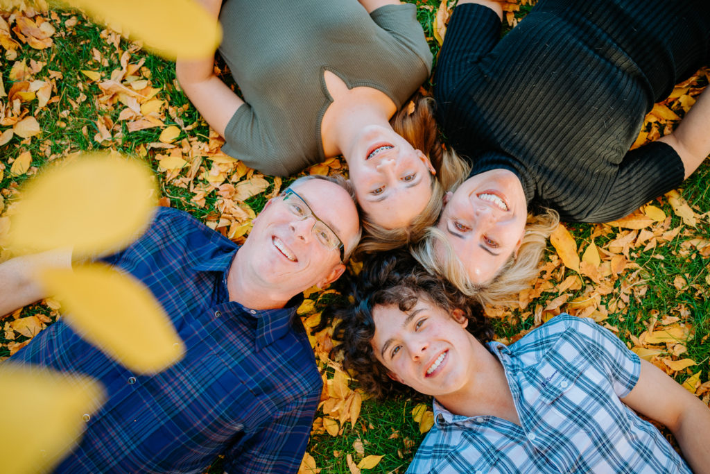 Colorado Fall Family Photo Tips | Smiling Family portrait from above with fall leaves