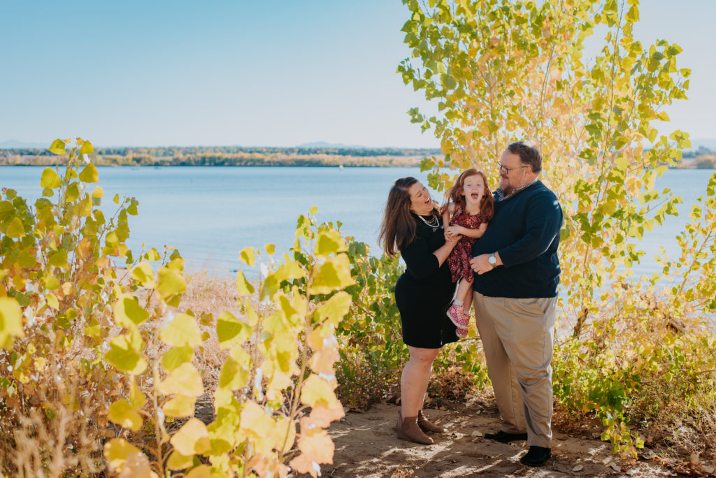 Colorado Fall Family Photo Tips | Family poses in autumn in front of a lake and lots of foliage