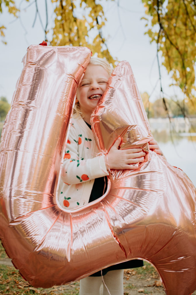 Colorado Fall Family Photo Tips | Kid celebrates fourth birthday with big balloon in the fall