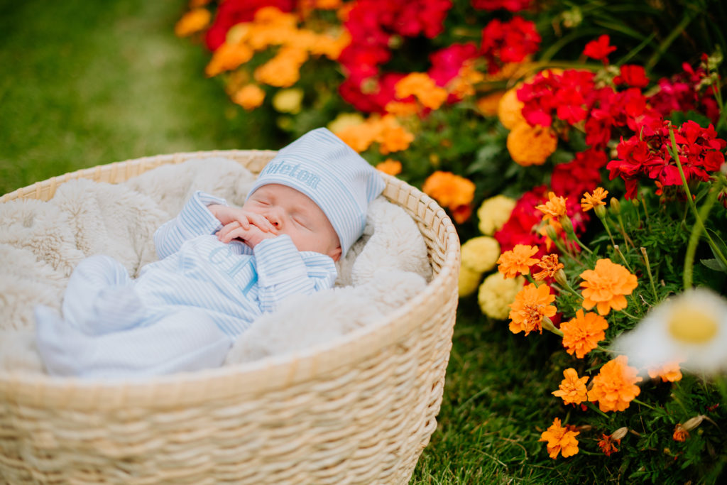 Newborn photography | Sleeping baby in a wicker basket with flowers