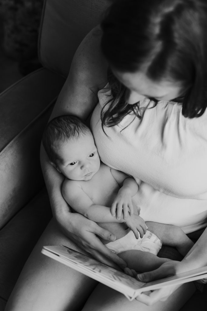 Newborn photography | Black and white portrait of a newborn listening to mom read them a book