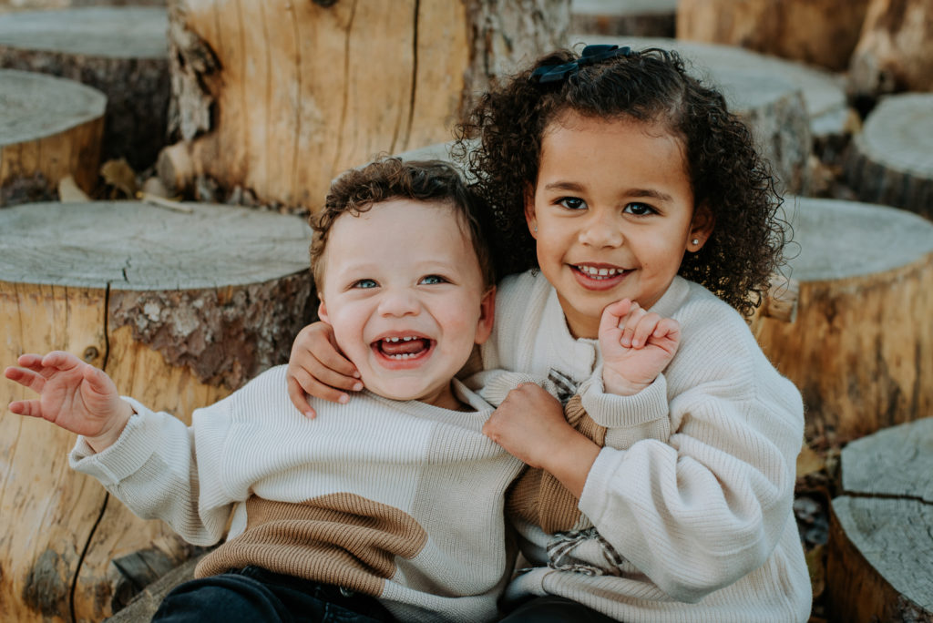 Colorado Fall Family Photo Tips | Siblings smile on a warm fall day with an autumnal mountain background