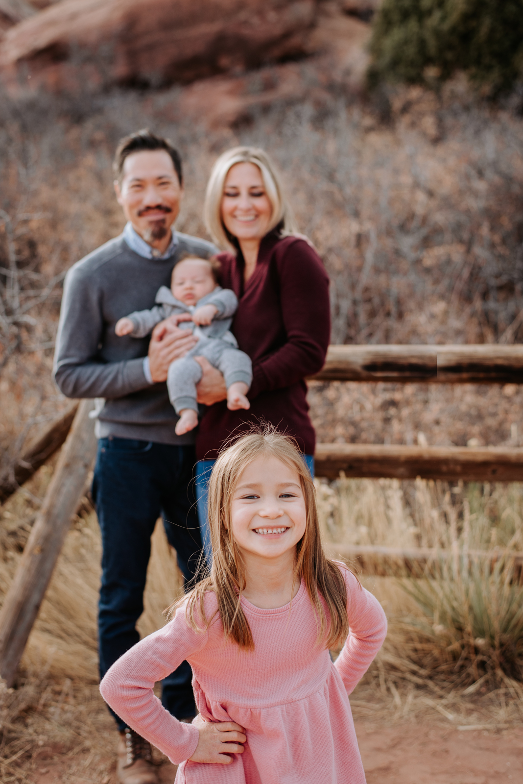 Colorado Fall Family Photo Tips | Family poses by a fence in autumn with muted colors
